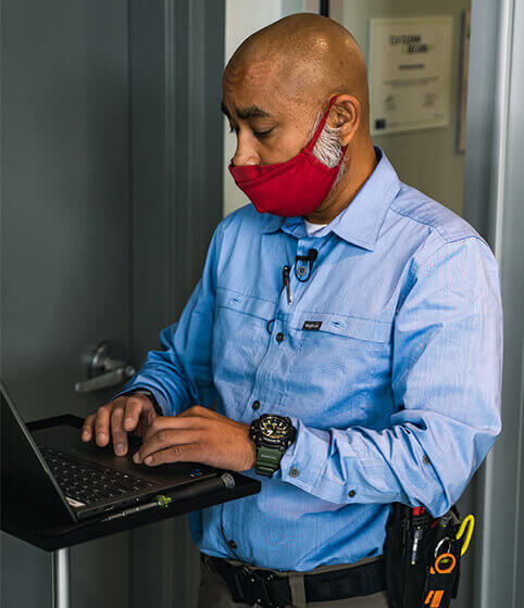 Man with mask working on laptop