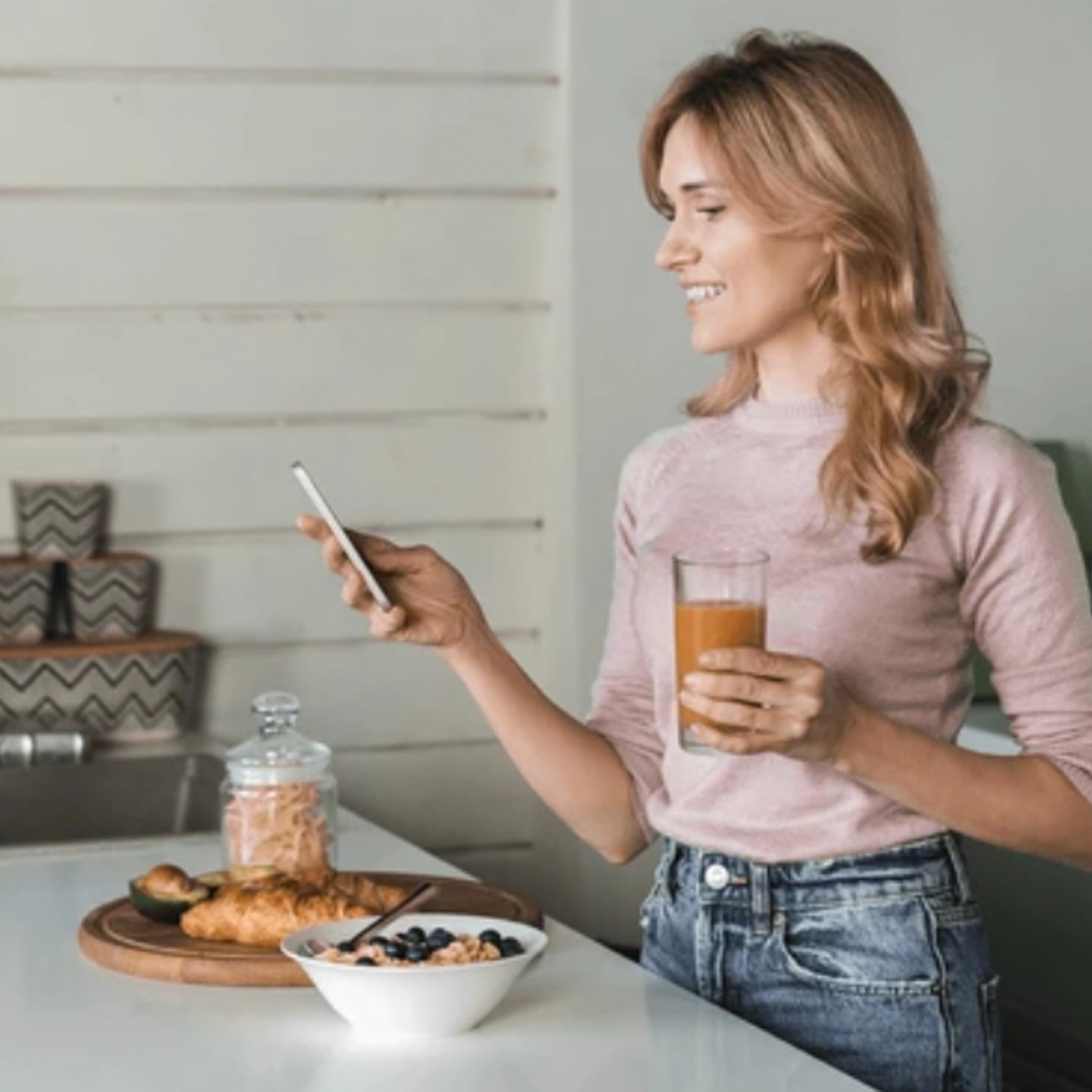 Woman using his phone while drinking a beverage